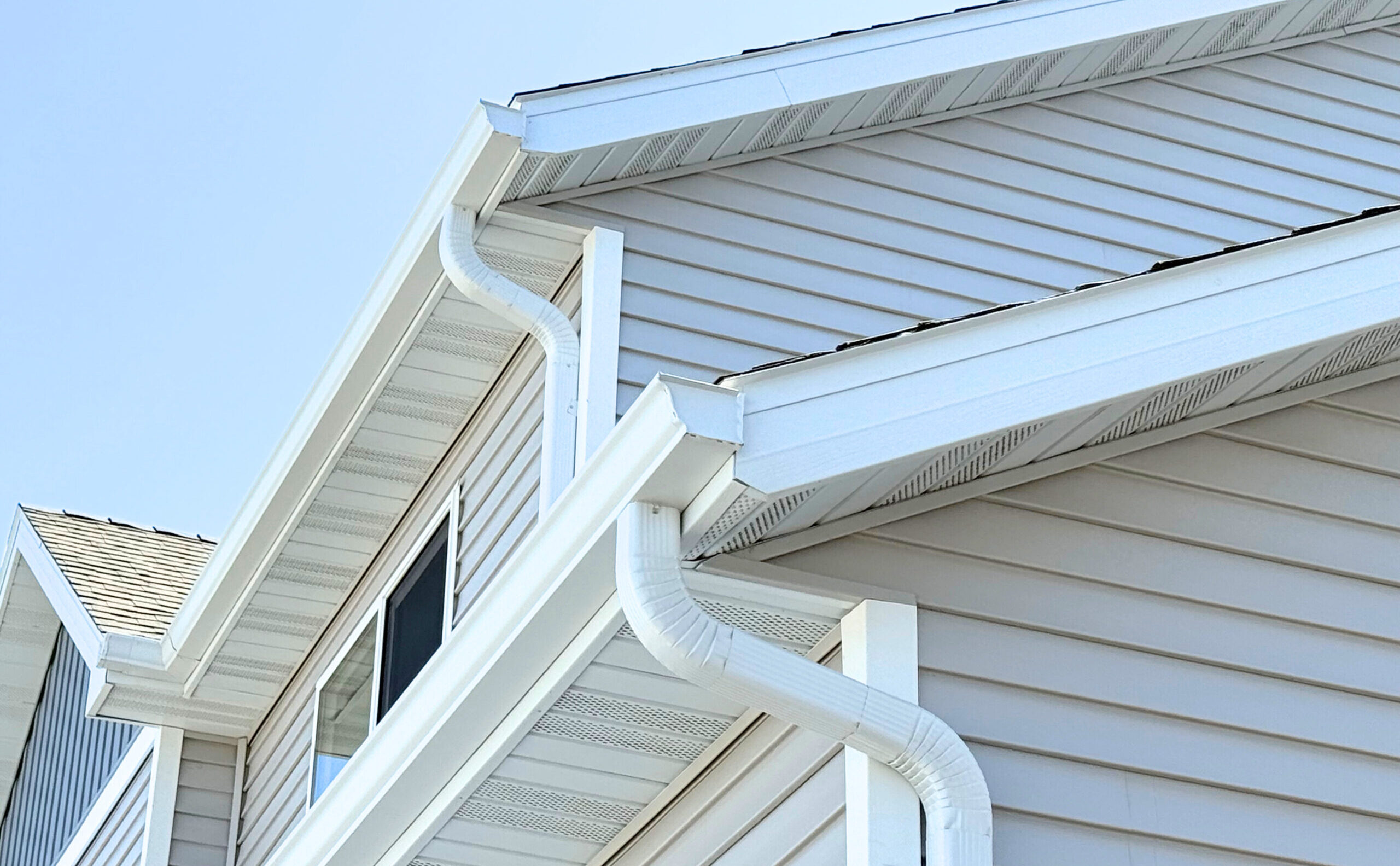 White gutters and downspouts on a two-story home
